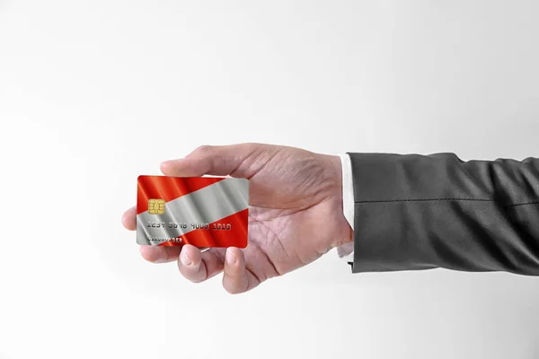 Hombre en elegante traje personalizado con tarjeta de crédito bancaria de plástico con bandera de Austria — Foto de Stock