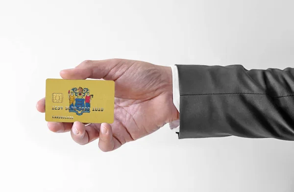 Bank karta kredytowa z flagą stanu Usa New Jersey gospodarstwa człowiek w eleganckim garniturze — Zdjęcie stockowe