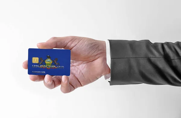 銀行クレジットプラスチックカードアメリカの国旗ペンシルベニア州エレガントなスーツの男を保持 — ストック写真