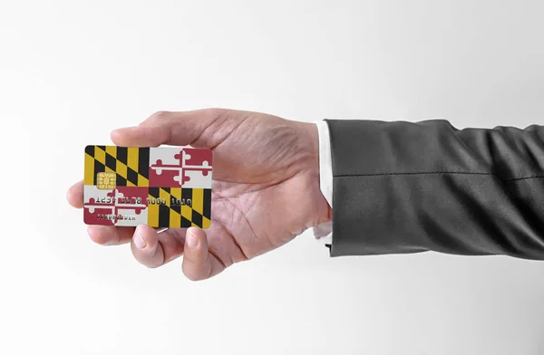 Τράπεζα πιστωτική κάρτα πλαστική με τη σημαία της πολιτείας της Usa Maryland κρατώντας άνθρωπος σε κομψό κοστούμι — Φωτογραφία Αρχείου