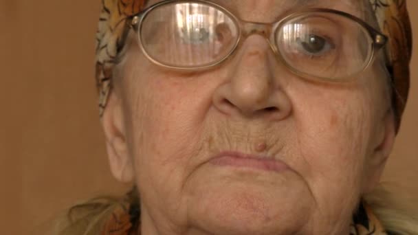 Бабушка (пожилая женщина) поправляет очки — стоковое видео