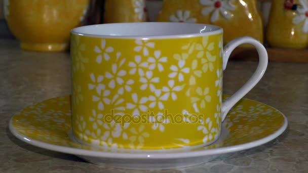 On the yellow saucer is a yellow cup — Stock Video