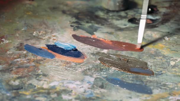 Painting with oil paints with a palette. Close-up of oil paint on the palette. The process of creating oil painting — Stock Video