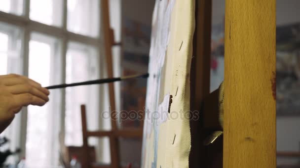 Yağlı boya ile onun şövale sanatçı resim. Modern sanatçı onun üzerine yağlıboya resimde boyar. Sanatçı çalışırken portresi — Stok video