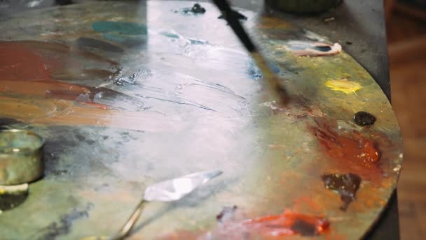Malerei mit Ölfarben mit einer Palette. Nahaufnahme von Ölfarbe auf der Palette. der Prozess der Schaffung von Ölgemälde — Stockvideo