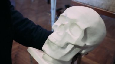 bir insan kafatası çizim. Sanatçı hayattan bir insan kafatası bir kroki çizer. Alçı kafatası ve sanat.