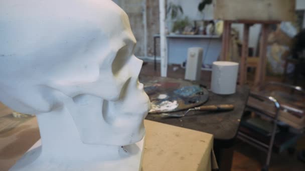 Drawing a human skull. The artist draws a sketch of a human skull, from life. Plaster skull and art. — Stock Video