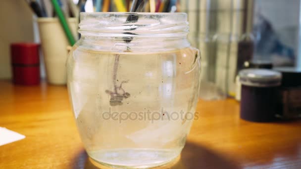 Drops of watercolors into the water. The process of dissolving the dye in water. Creativity at home — Stock Video