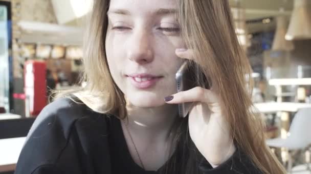 De Europeanen glimlachend meisje praten aan de telefoon. Positieve gesprek van een meisje op de telefoon. Moderne communicatie en sociale netwerken — Stockvideo