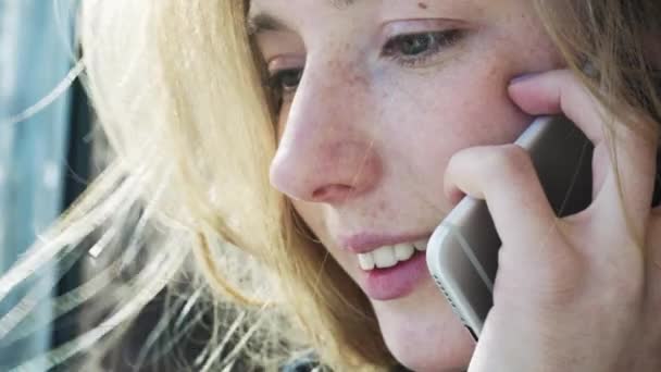 Европейцы улыбаются девушке, разговаривающей по телефону. Позитивный разговор девушки по телефону. Современные коммуникации и социальные сети — стоковое видео
