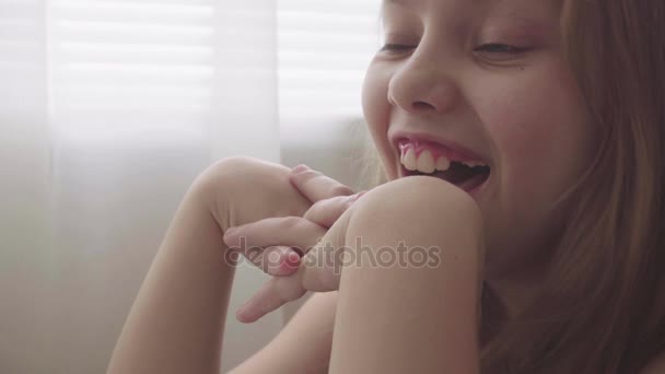 Europäisches Porträt eines lachenden kleinen Mädchens, das den Film anschaut. Lustige Videos online für Kinder — Stockvideo