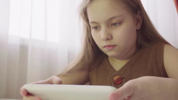 Niña sosteniendo una tableta. Juegos para niños en la tableta — Vídeo de stock