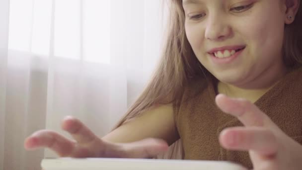 Menina segurando um tablet. Jogos de crianças no tablet — Vídeo de Stock
