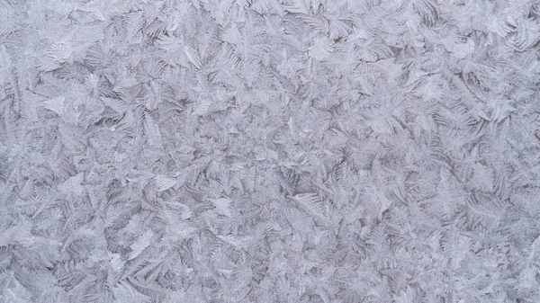 Изображение мороза на стекле. На улице температура ниже нуля. Замороженные кристаллы воды на стекле — стоковое фото