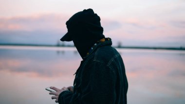 deniz arka plan üzerinde telefonu kullanan adam. Telefonu kullanarak bir Avrupa Close-up. Sığ odak 