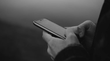 deniz arka plan üzerinde telefonu kullanan adam. Telefonu kullanarak bir Avrupa Close-up. Sığ odak 