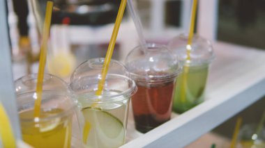 Yaz plastik içer. Yaz serinletici bir saman ve meyve ile içer. Sığ odak 