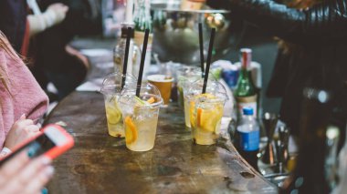 Yaz plastik içer. Yaz serinletici bir saman ve meyve ile içer. Sığ odak 