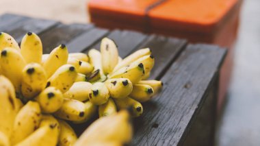 bir sürü olgun muz bir ahşap masa yakın çekim üstten görünüm üzerinde yalan. Tropikal meyve ve yolculukta Bapu diyet. Asya'nın tropikal meyveler