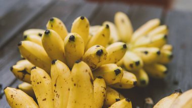 bir sürü olgun muz bir ahşap masa yakın çekim üstten görünüm üzerinde yalan. Tropikal meyve ve yolculukta Bapu diyet. Asya'nın tropikal meyveler