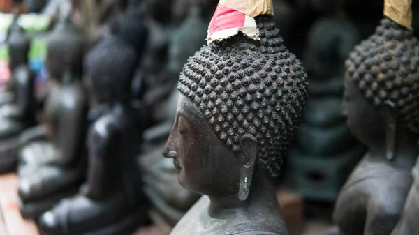 Velhas estátuas de Buda no mercado local close-up. Buda como um símbolo do budismo na Tailândia e Ásia. Retrato de um buda em formato de estátua no mercado local — Fotografia de Stock
