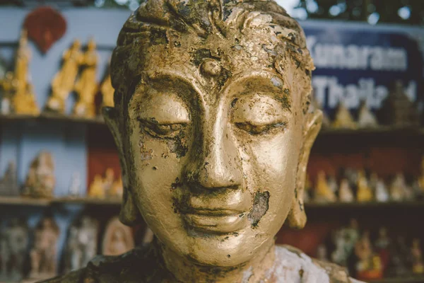 Buddha statue as amulets of Buddhism religion close-up. Old Buddha face