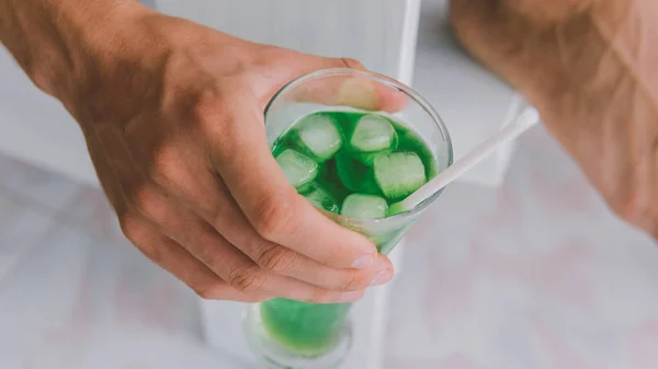 Gros plan d'un soda avec des cubes de glace dans un verre. Boisson fraîche avec glace de couleur verte — Photo