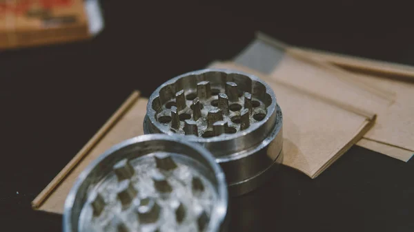 Kovový stříbrný bruska pupeny marihuany ležící na kouř papíry detail. Legalizovat koncept — Stock fotografie