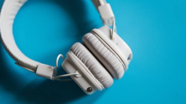 Turkuaz arka plan top yakın çekim beyaz kablosuz kulaklıktan görüntülemek.