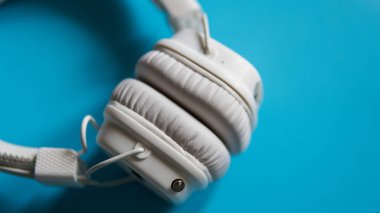 Turkuaz arka plan top yakın çekim beyaz kablosuz kulaklıktan görüntülemek.