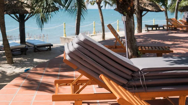 Tumbonas cerca de la piscina del hotel. Vacaciones tropicales en Asia, concepto milenario — Foto de Stock