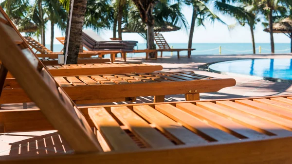 Tumbonas cerca de la piscina del hotel. Vacaciones tropicales en Asia, concepto milenario —  Fotos de Stock