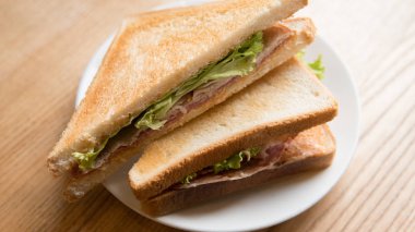  pişmiş sandviç salam ve marul yaprakları. Bir ofis çalışanı için hızlı snack