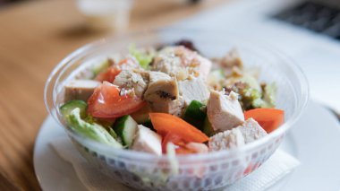  Domates salatası götürün ve plastik ambalaj içinde tavuk. Ofis çalışanları iş yeri için yararlı bir aperatif