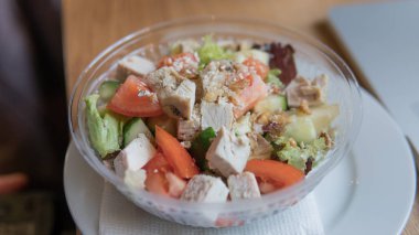  Domates salatası götürün ve plastik ambalaj içinde tavuk. Ofis çalışanları iş yeri için yararlı bir aperatif