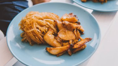 El yapımı erişte ile eller yakın turkuaz tabakta tavuk 