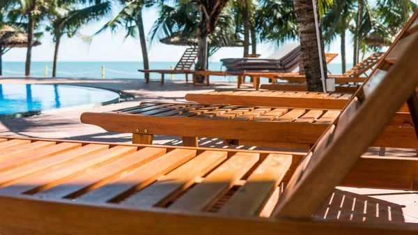 Tumbonas cerca de la piscina del hotel. Vacaciones tropicales en Asia, concepto milenario — Foto de Stock