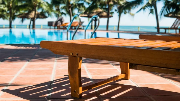 Chaises longues près de la piscine de l'hôtel. Vacances tropicales en Asie, concept millénaire — Photo