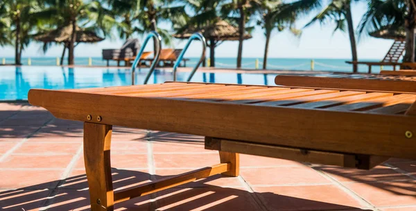 Tumbonas cerca de la piscina del hotel. Vacaciones tropicales en Asia, concepto milenario — Foto de Stock