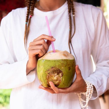 Kadın ellerinde hindistan cevizi içmek..