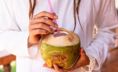 Kadın ellerinde hindistan cevizi içmek..