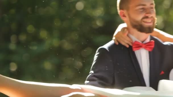 Bruidegom draaiingen met een gelukkige bruid op zijn handen — Stockvideo