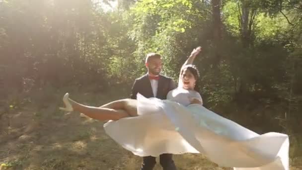 Bruidegom draaiingen met een gelukkige bruid op zijn handen opeenvolging — Stockvideo