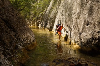 Adam dar dağ Kanyon nehir onun ayakkabılarla elinde yürür