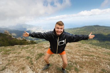 Mutlu gülümseyen adam sahanın açık dağın tepesinde elleri ve güçlü expession yaz dağ ile kameraya bakarak manzara gezi hiking