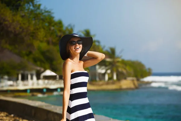Junge Frauen mit Strohhut und stylischem Strand genießen die tropische Sonne. Sommerpflegekonzept. hübsches Mädchen im Urlaub auf der Insel in der Nähe des Ozeans. — Stockfoto