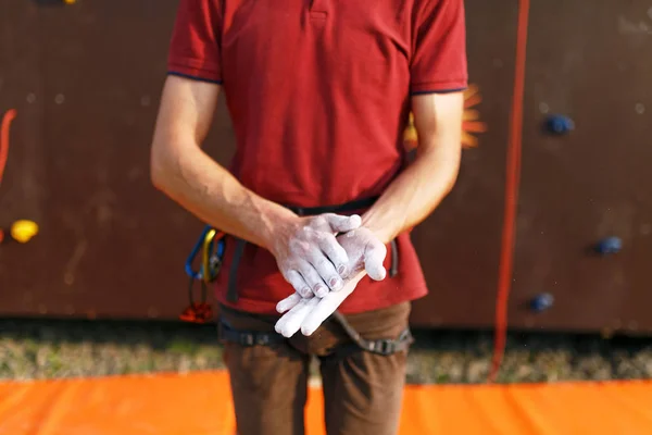 Primer plano del escalador hombre cubriendo las manos en polvo tiza magnesio y preparándose para escalar entrenamiento entrenamiento al aire libre pared de roca . — Foto de Stock