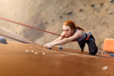 Güçlü kadın ve iş başarı kavramı. Açık havada yapay kaya duvara tırmanma pratik genç Kafkas güzel kadın. Hız bouldering oturum eğitim ince sportif kız.