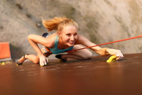Starke Frau und unternehmerisches Erfolgskonzept. junge kaukasische hübsche Frau beim Klettern an einer künstlichen Felswand im Freien. schlanke sportliche Blondine beim Speed-Bouldern. — Stockfoto
