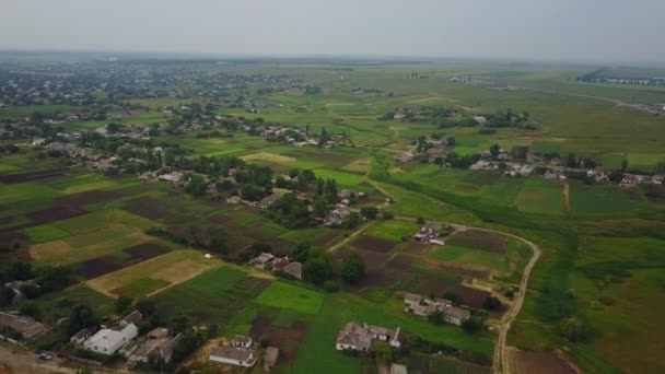 Luchtfoto van het gewone Oekraïense dorp. Uitzicht vanaf de boven van platteland in Oekraïne. Oude huizen, plantaardige tuinen en velden. Vruchtbare humus land. — Stockvideo